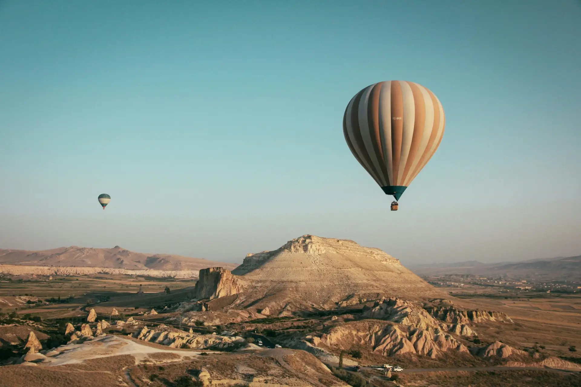 Ana Sayfa Hot air balloons float over the mesmerizing landscape of Cappadocia, Turkey at sunrise.