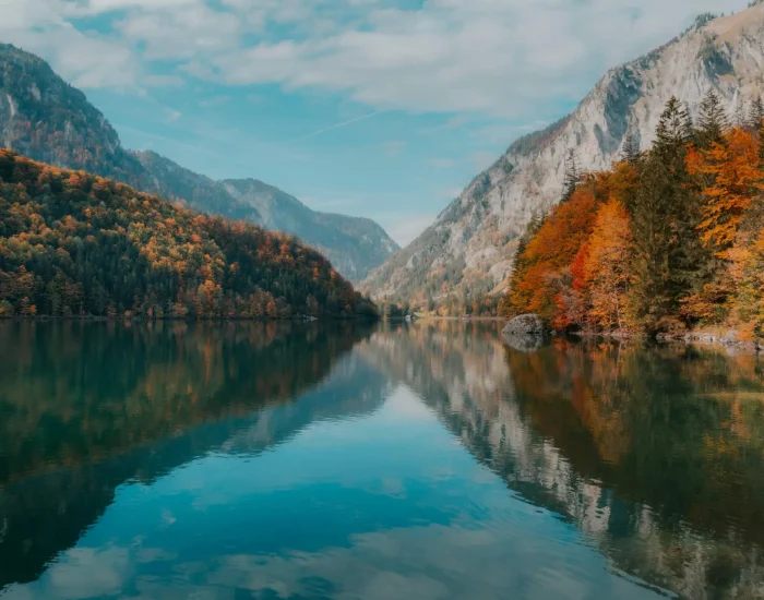 Peaceful autumn lake with colorful foliage reflecting mountains in Eisenerz, Austria.